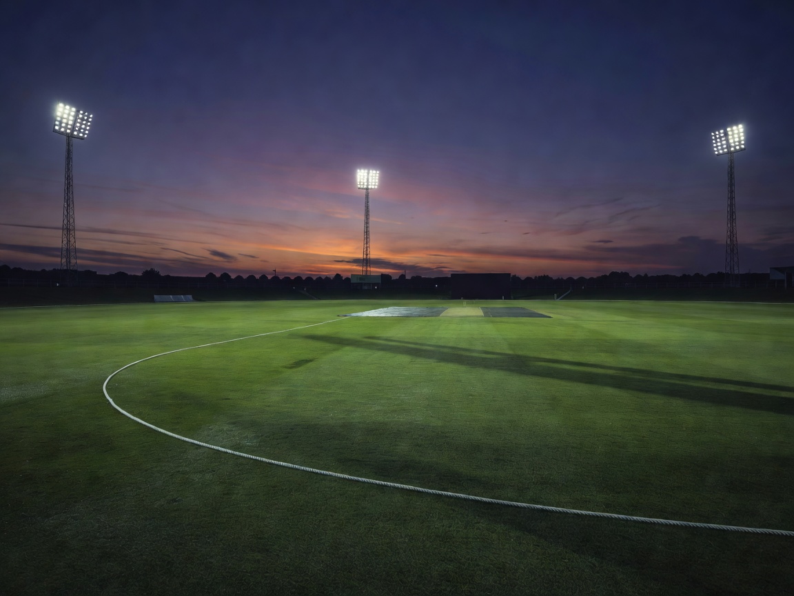 Illustration of an international cricket ground at dusk, with floodlight pylons above an empty outfield and the boundary rope curving away from a covered pitch